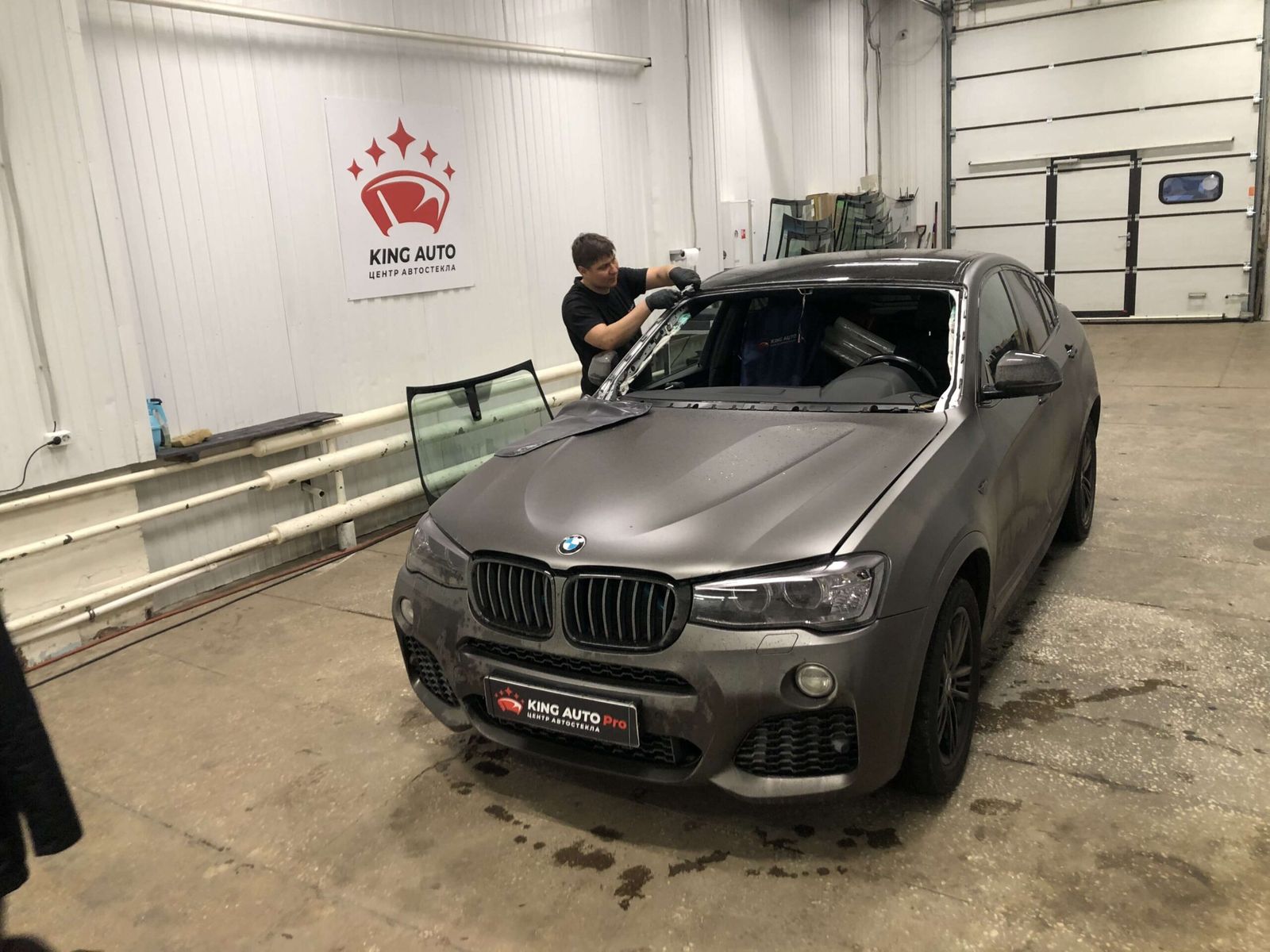 BMW X-серии в боксе, рядом стойка с новым лобовым стеклом