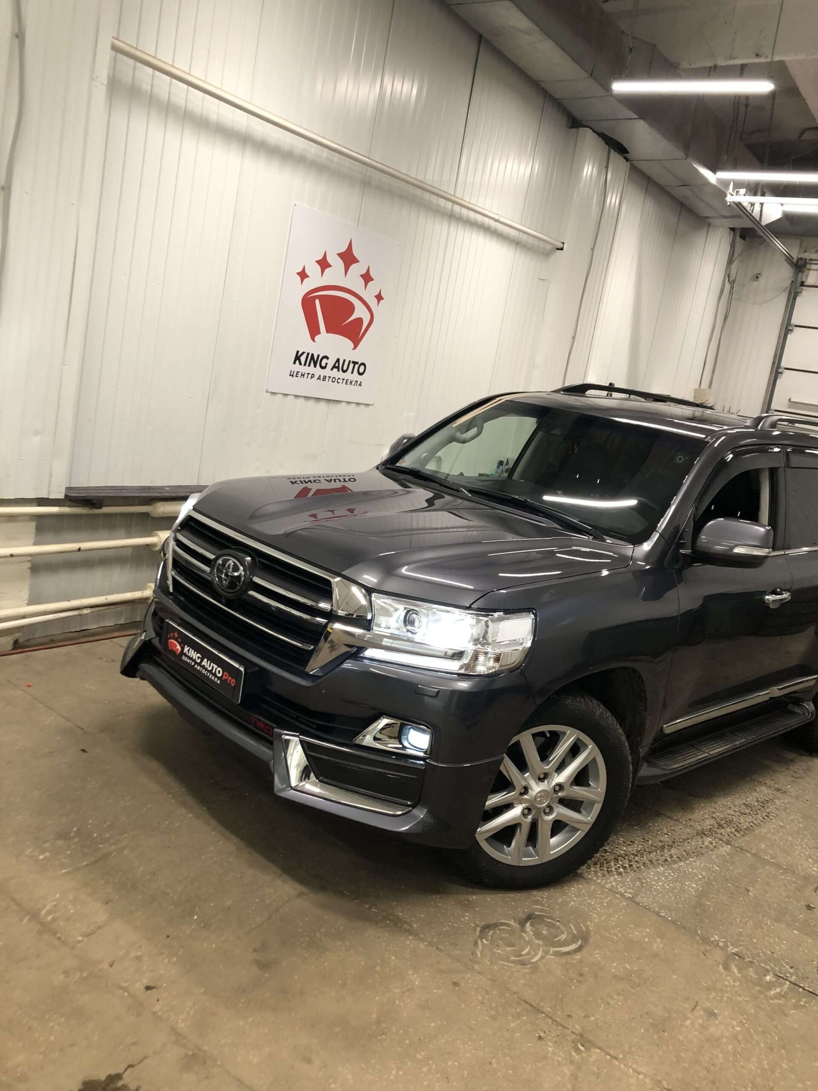 Toyota Land Cruiser 200 в боксе KING AUTO Pro — логотип с короной на стене