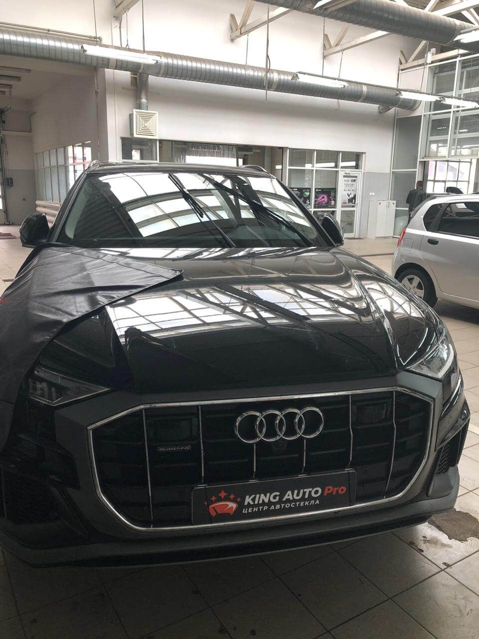 Audi Q-серии с защитной накидкой на капоте перед заменой стекла