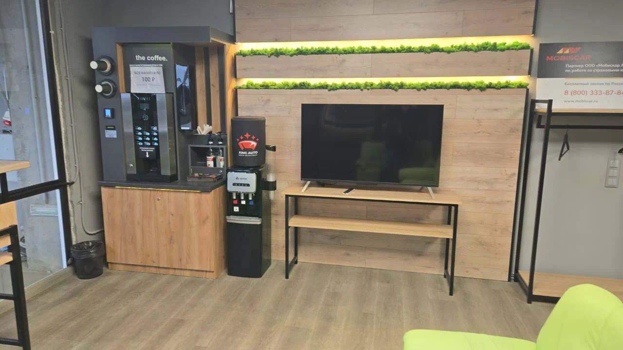 Кофемашина, телевизор и стеллаж в клиентской зоне